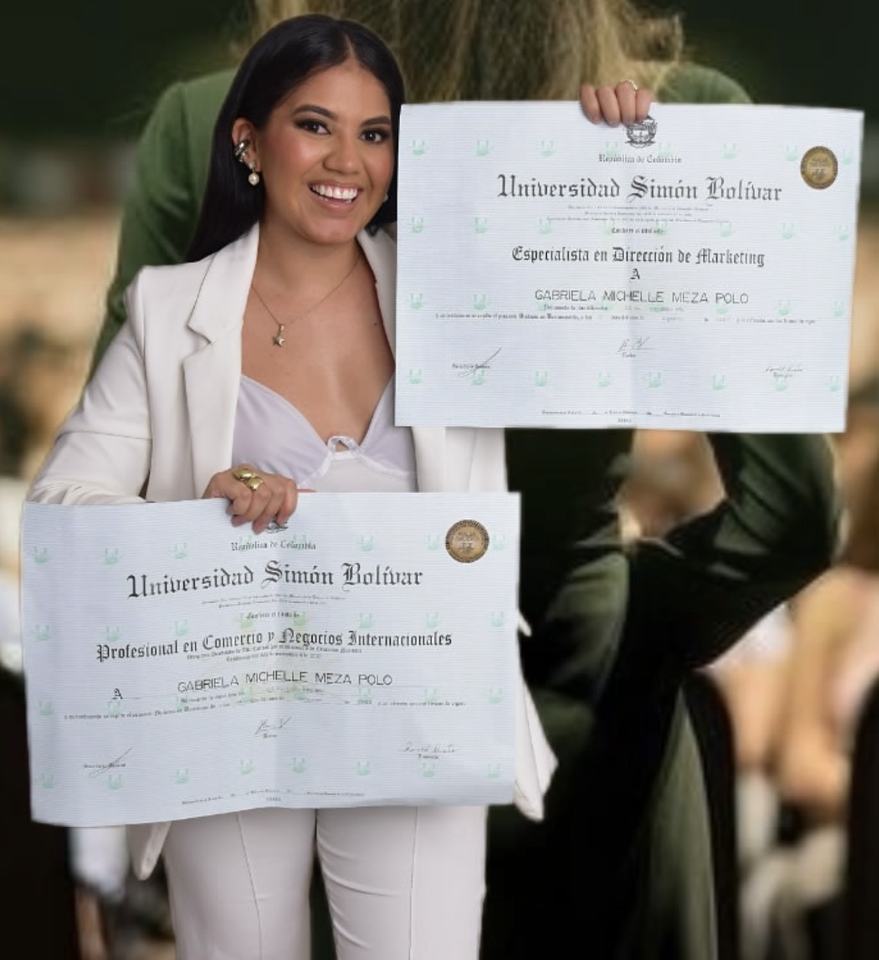 Gabriela Michelle sosteniendo sus diplomas de la Universidad Simón Bolívar